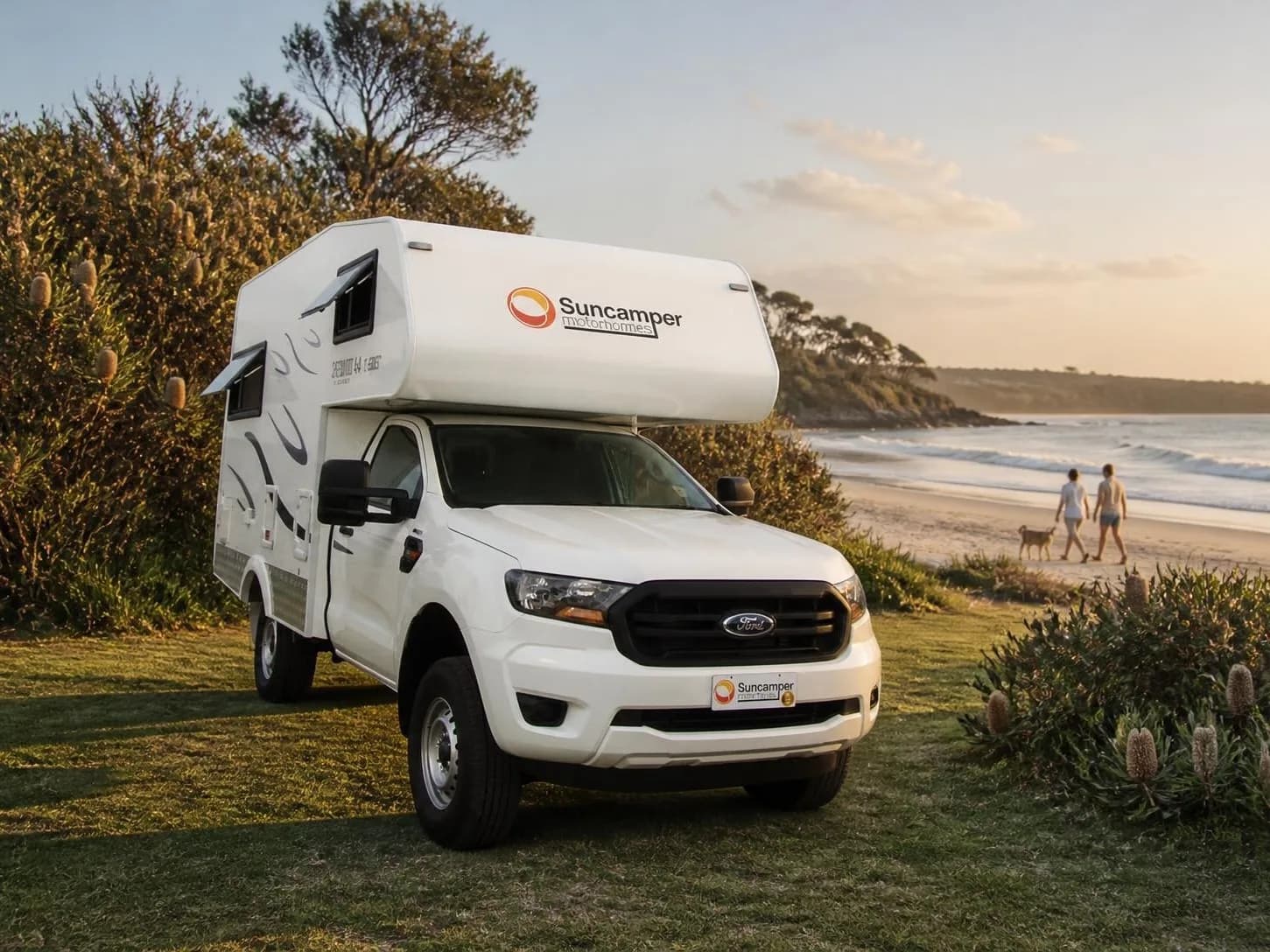 Compact motorhome on a utility chassis parked by the water